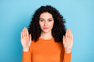 Portrait of attractive brunet content strict girl showing stop sign palms isolated over bright blue...
