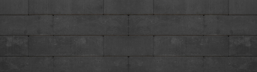 Black anthracite retaining wall garden from concrete shuttering blocks masonry brickwork wall texture banner panorama