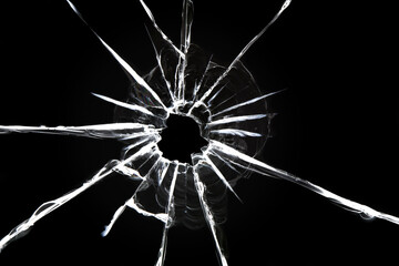 Cracked glass on a black background. Broken window. Bullet hole, abstraction for design