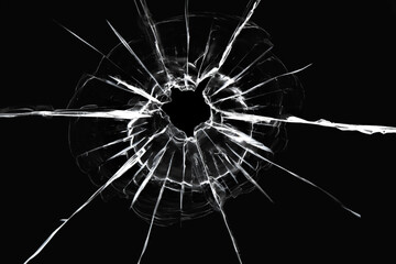 Cracks in the window from a shot from a weapon. Damaged window glass. White cracks on a black...