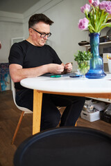 Mature craftsman working on a new necklace