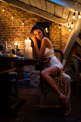 Obraz na płótnie Canvas Sensual fashion woman near candles in evening