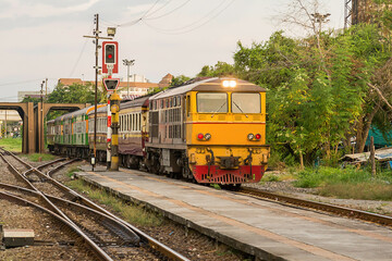 Locomotive train on railroad tracks from Thailand go into train station. Transport  move passenger to station. Railway Tracks at a Major Train Station. traditional transport.