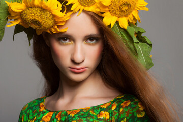 Woman with stylish makeup and sunflowers around her head