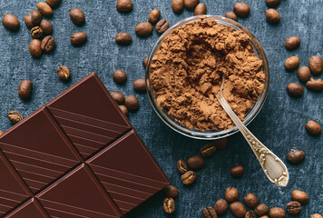 Cocoa powder, fresh fried coffee beans and chocolate bar, close up