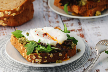 Homemade sandwiches with pesto, green salad and poached eggs