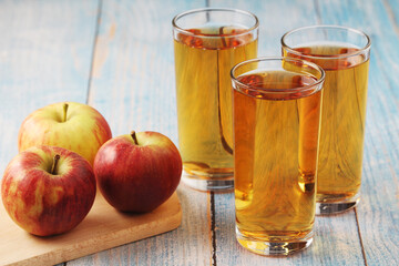 A glass with apple juice and ripe apples