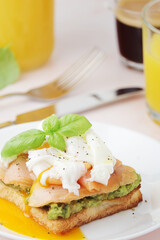 Breakfast with a sandwich with poached egg and avocado