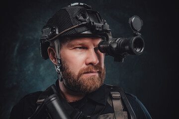 Modern soldier looks in night vision device inbuilt in his helmet