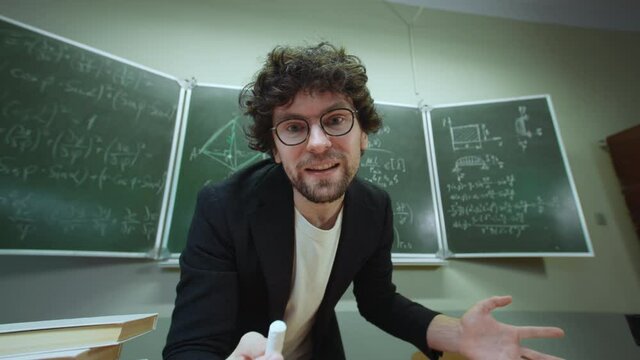 Emotional Eccentric Teacher Trying Explain Mathematical Formulas Written In Chalk On Blackboard In Classroom. POV View Funny Professor Emotionally Speaking To Pupil Who Does Not Understand Math