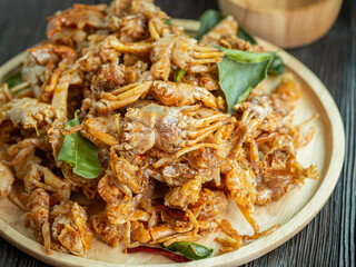 Fried crab and herb on wooden dish and black wood background. Thai and spicy food. Selective focus.