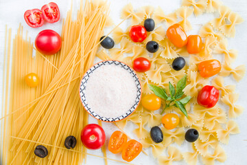 Pasta ingredients, raw pasta, cherry tomatoes, olives, salt and basil leaves