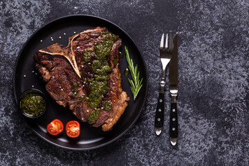 Grilled beef steak with spices on a black plate