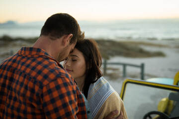 Happy caucasian couple on the beach touching foreheads