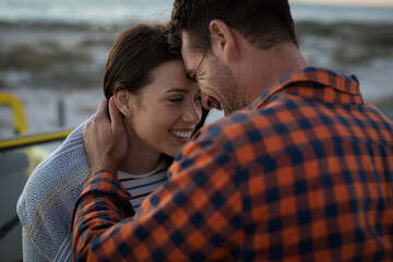 Happy caucasian couple on beach at the sea touching foreheads