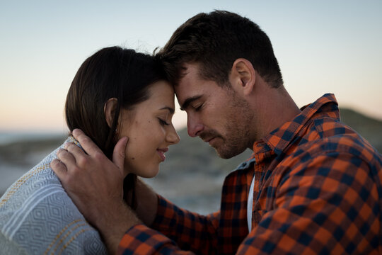 Happy Caucasian Couple On Beach At The Sea Touching Foreheads