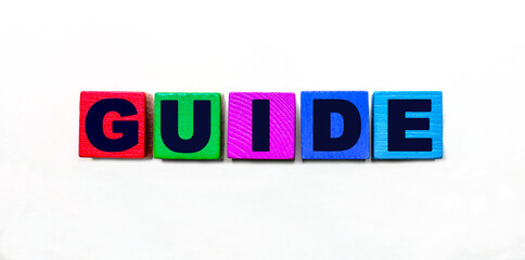 The word GUIDE is written on colorful cubes on a light background