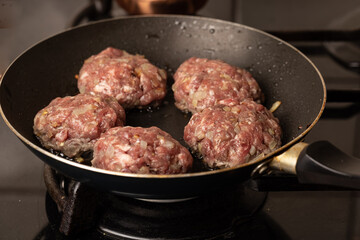 The process of cooking and roasting beef meat cutlets in a frying pan