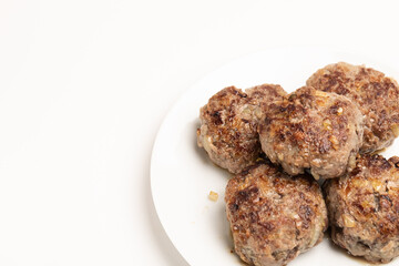 Ready-to-eat homemade beef cutlets. Appetizing cauldrons on a white plate on a white background.