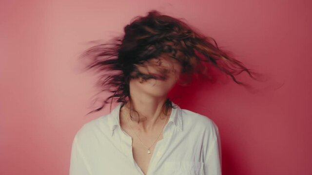 Young woman shaking her head isolated over pink background