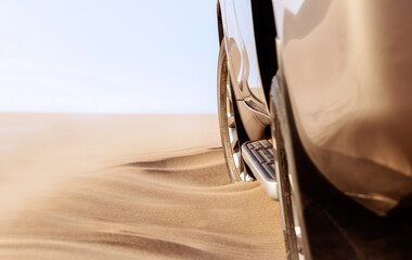 Close up of a golden car stuck in the sand in the Namib desert.