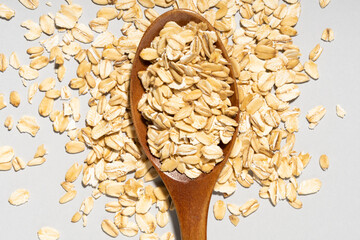 wooden spoon and oatmeal on gray background