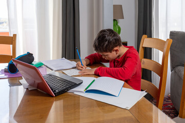 boy doing his homework while lock down, studying remotely