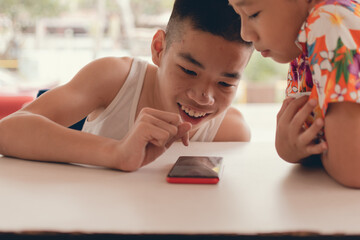 Disabled child on wheelchair happy time to use a tablet in the house with little friend, Special children's lifestyle, Life in the education age of special need kids, Happy disability boy concept.