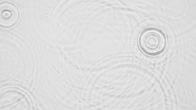 Up close, top view, Slow motion various waves of the water surface hitting the sun's rays, making them sparkle according to different patterns on a gray background video 4K.