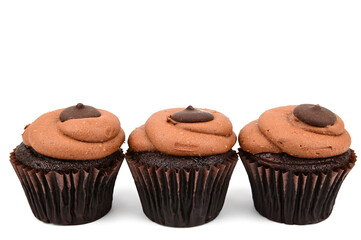 Three chocolate cupcakes in a row. The cakes are in decorative paper baskets