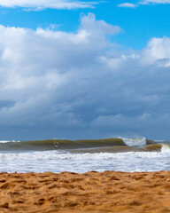 View of waves and surfers at Praia d'ulé in Guarapari, ES, Brazil.