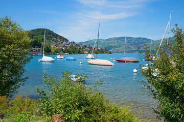 beautiful summer landscape lake Thunersee with swaying sailboats, tourist resort Faulensee