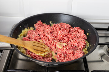 Beef and onion fried in a pan. Preparation of the dish.
