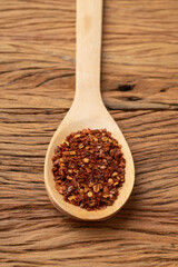 Closeup of dried calabrian chili pepper on a wooden spoon. Food backdrop