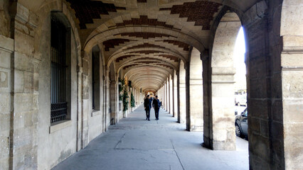 Beautiful archway in the old town country. Young people walking in historic place.
