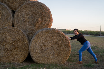 Cheerful, pretty and full of life girl enjoying a photoshoot in the straw