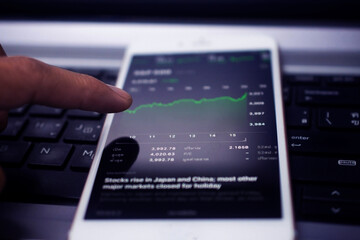Hand using smartphone trade stock market online business technology