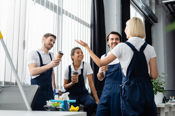 Positive interracial colleagues of cleaning service talking during coffee break in office