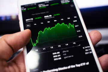 Hand using smartphone trade stock market online business technology