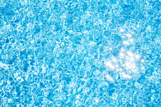 Sparkling reflections of sunlight on pool water surface