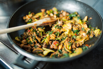 Mushrooms with meat and zucchini preparing in plate