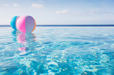 Beach balls floating on water in infinity pool