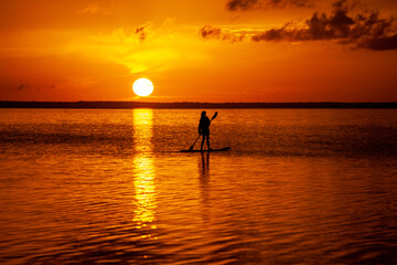 Stand up paddling into the sunset on the ocean