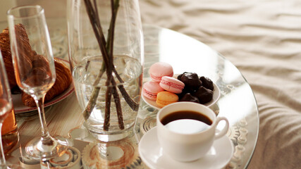 Glass table with a cup of coffee, sweet macaroons.