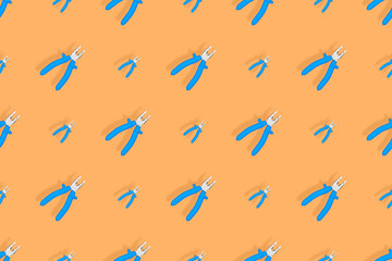 Background of metal pliers with rubber handles. Tools seamless pattern.