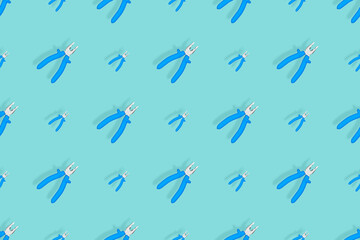 Background of metal pliers with rubber handles. Tools seamless pattern.