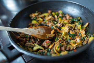 Mushrooms with meat and zucchini preparing in plate