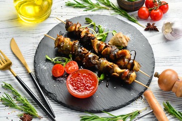 Rapana skewers with vegetables on a black stone plate. Restaurant food. Seafood. Rustic style. Flat Lay.