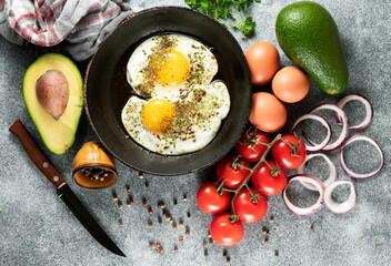 Fried eggs in a frying pan on a gray background
