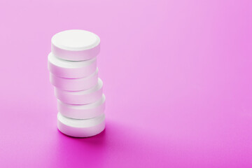 Ecstasy pills in a row on a pink background, isolate.